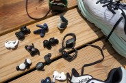variety of headphones laying next to shoes and an apple watch