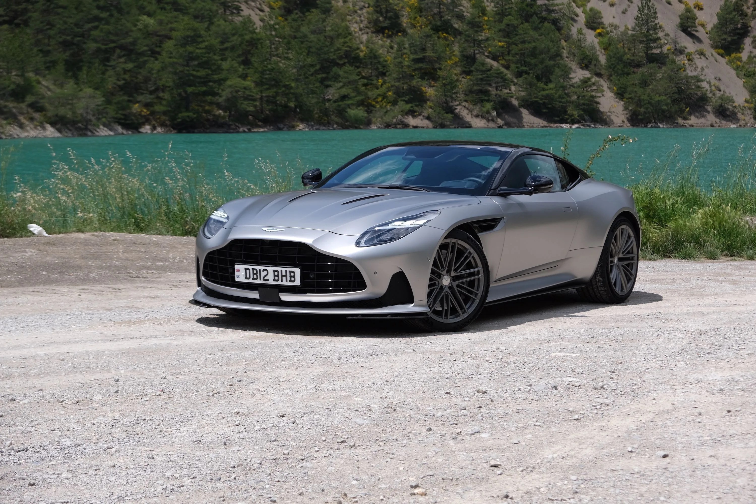 aston martin db12 parked next to lake