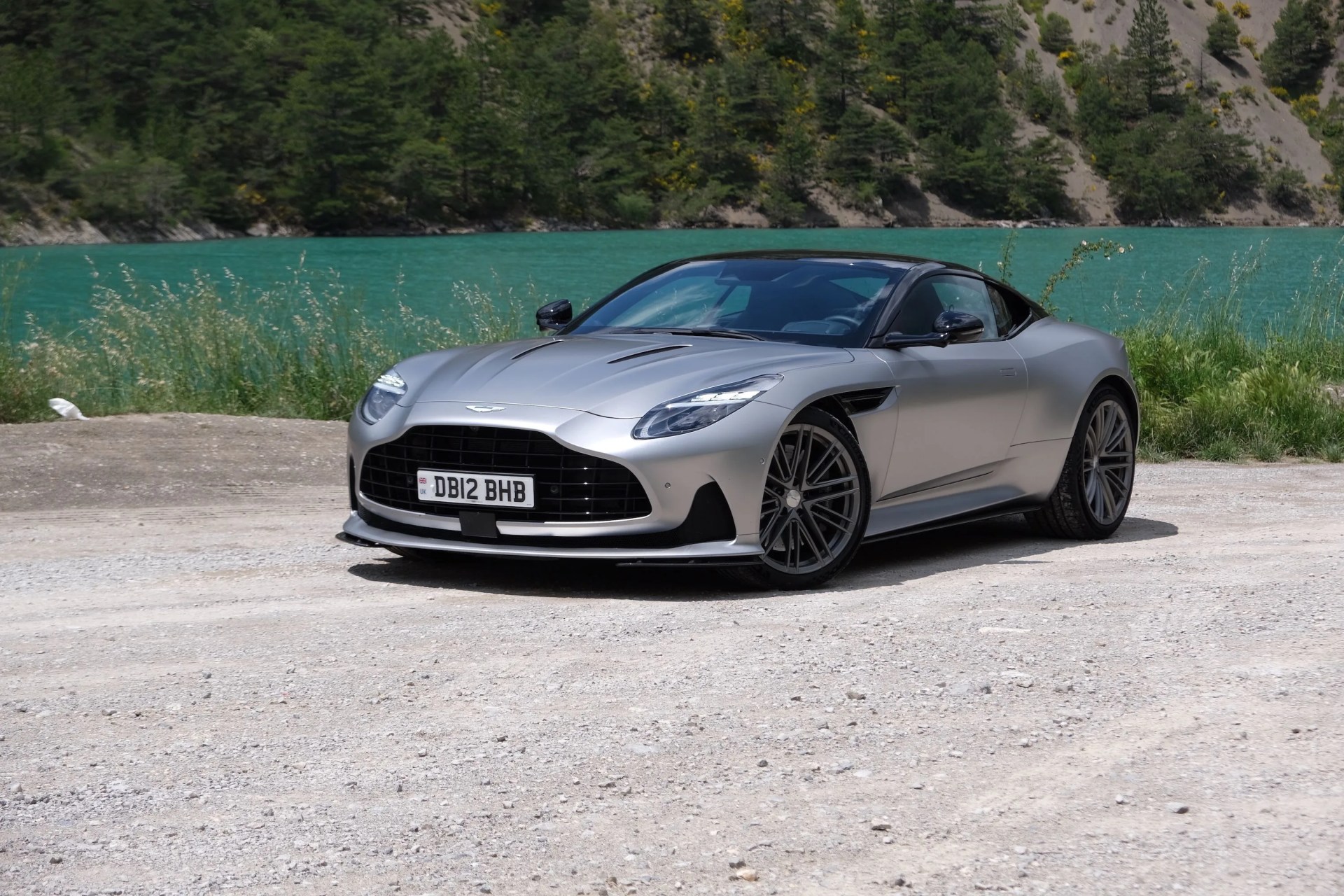 aston martin db12 parked next to lake