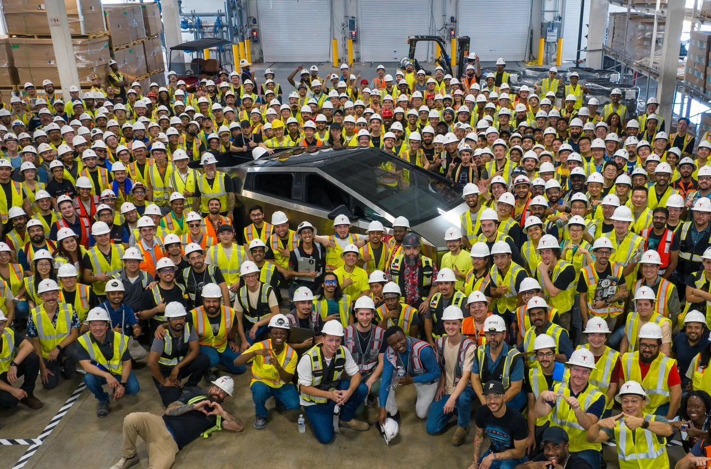first production cybertruck shrouded by employees