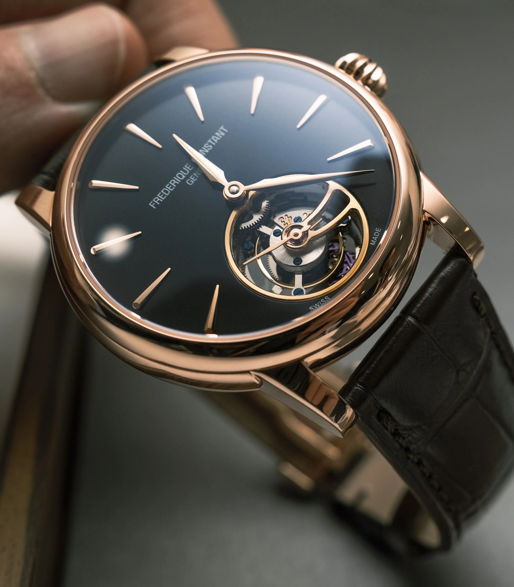 gold watch with tourbillon on its dial