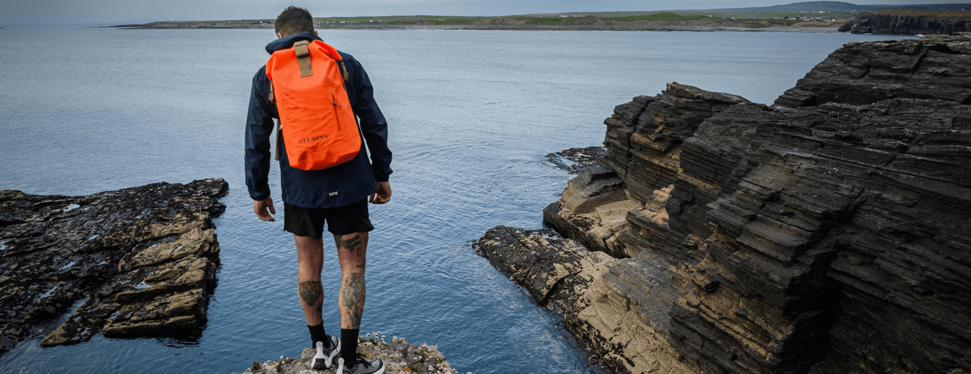 man standing on cliff over the ocean