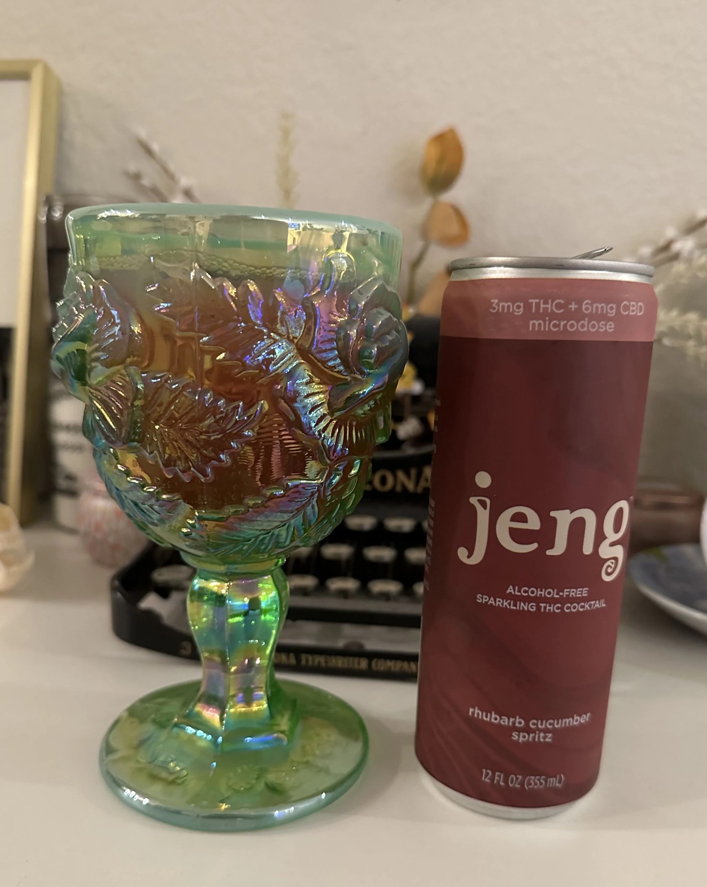 a can of jeng thc beverage next to a goblet