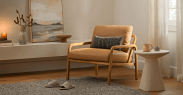 an armchair, side table and slippers by a window