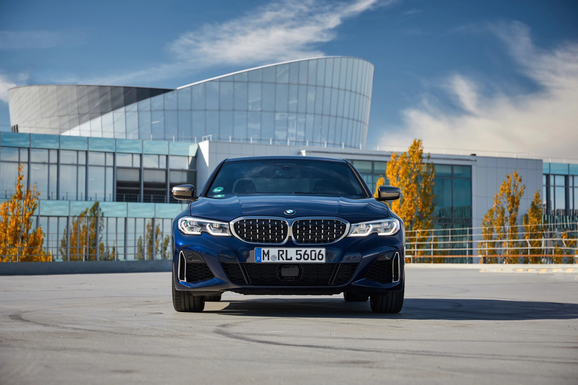 bmw 3 series viewed from the front parked in front of an office building