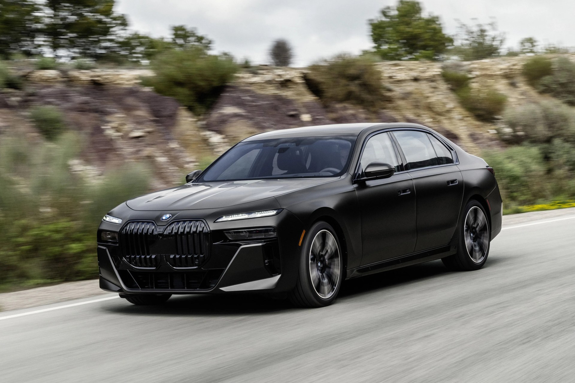 black bmw 7 series driving on road