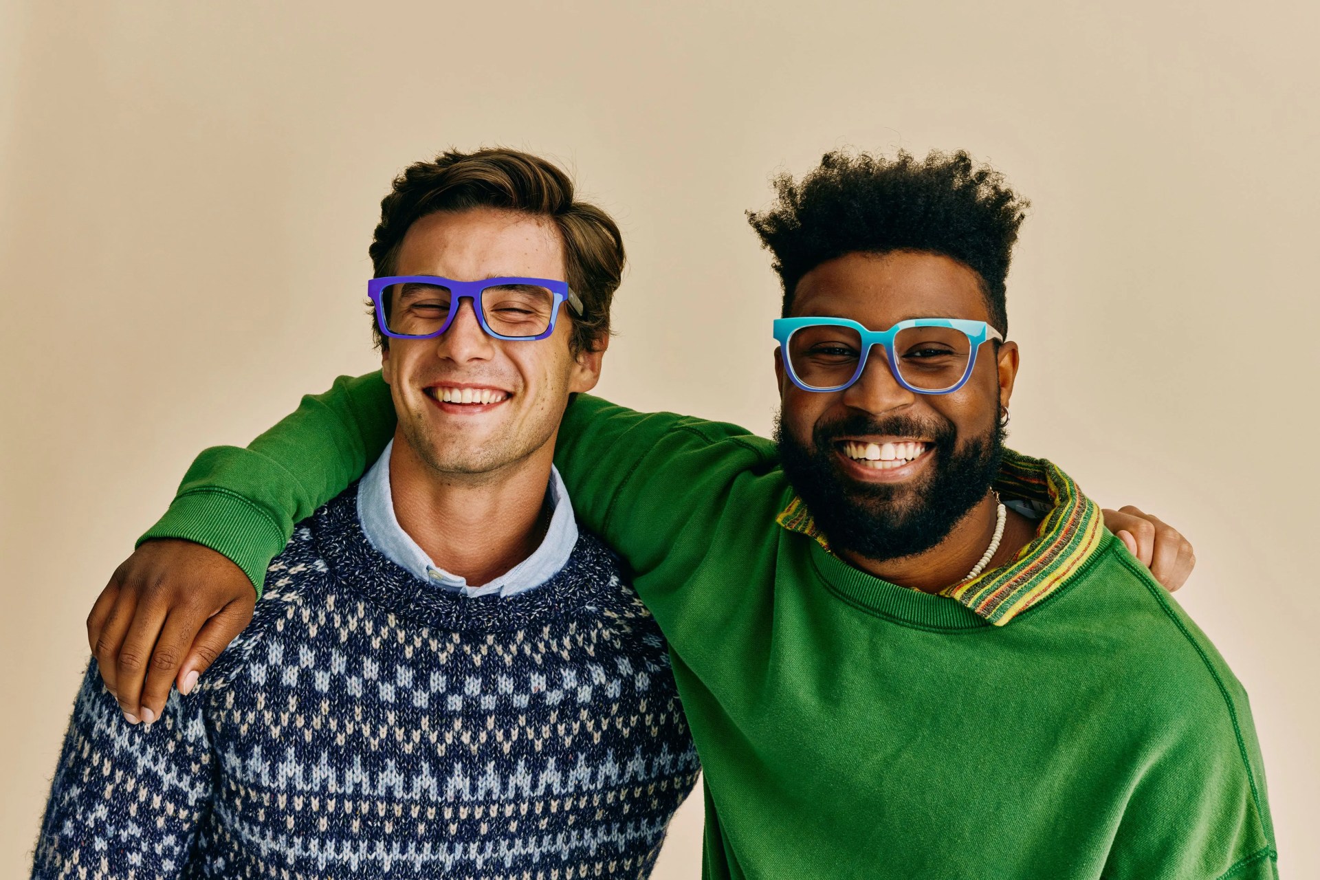 two men with their arms around each other's shoulders smiling while wearing pair eyewear