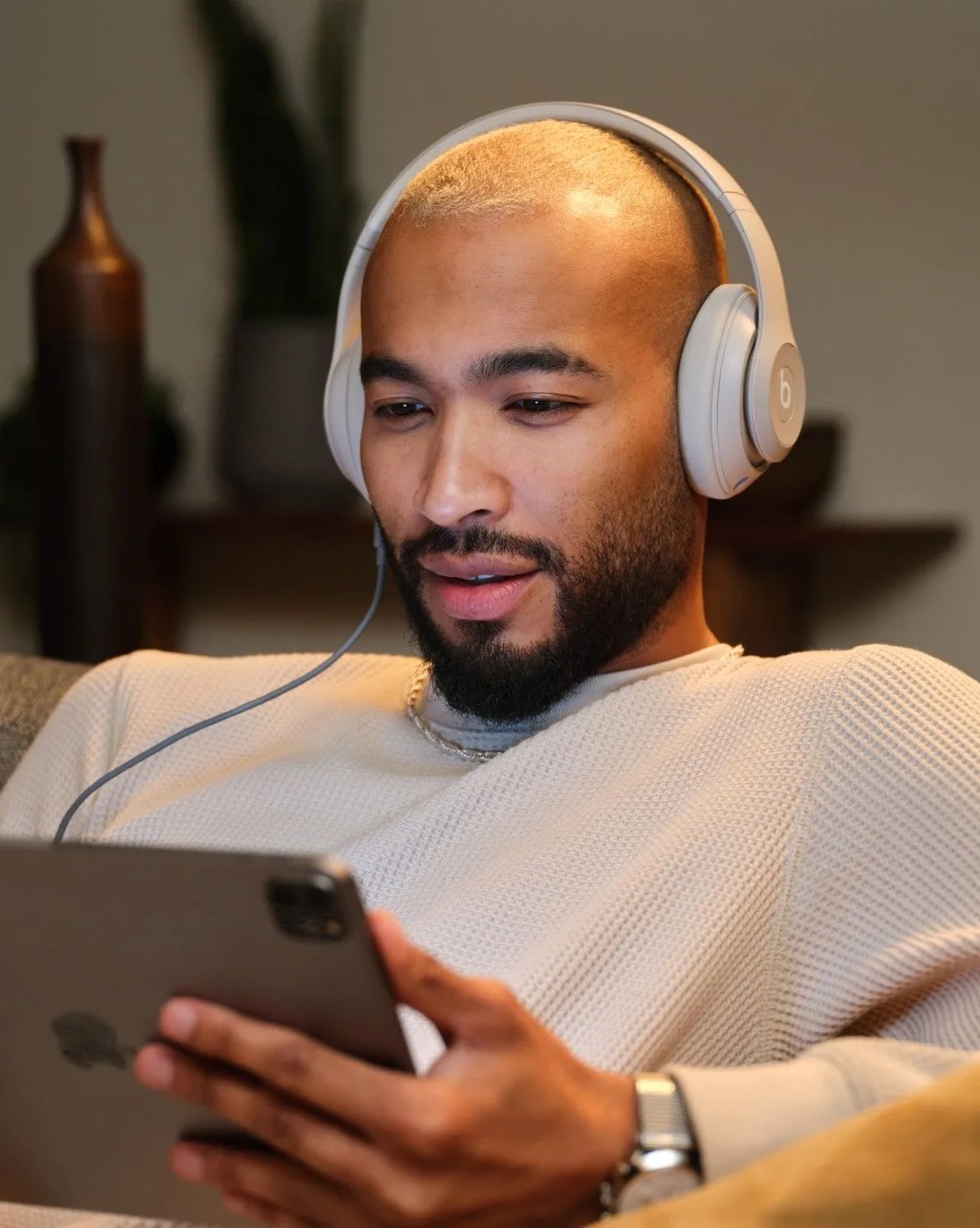 man wearing beats studio pro while using ipad