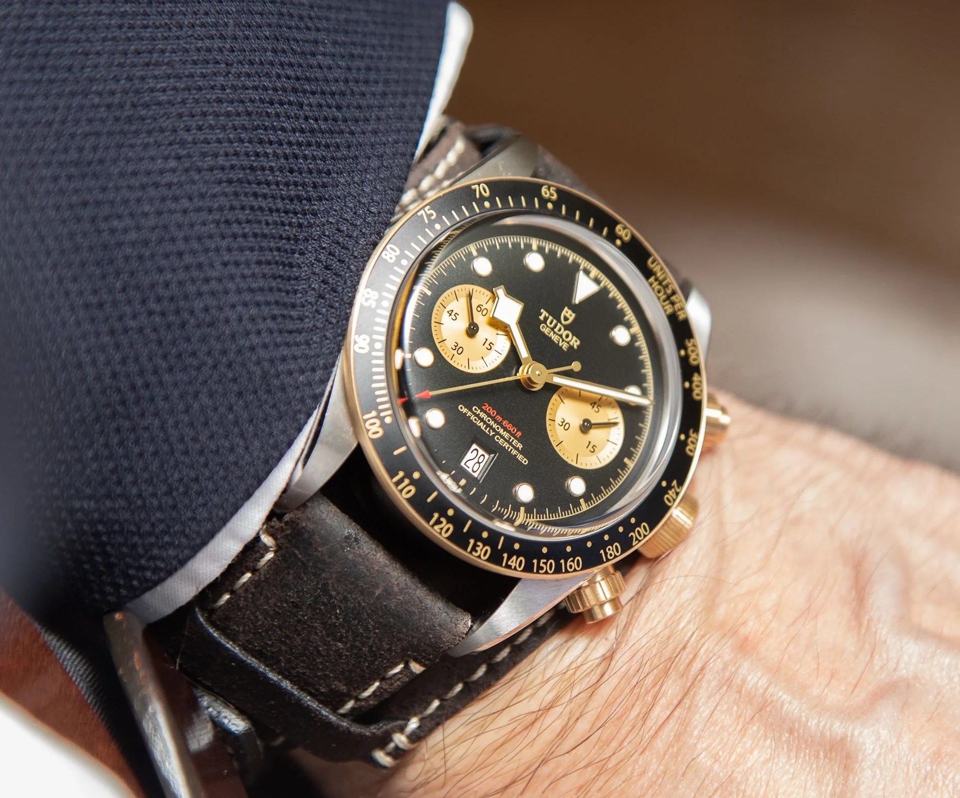 steel and gold wrist on leather cuff band on wrist with hand in pocket