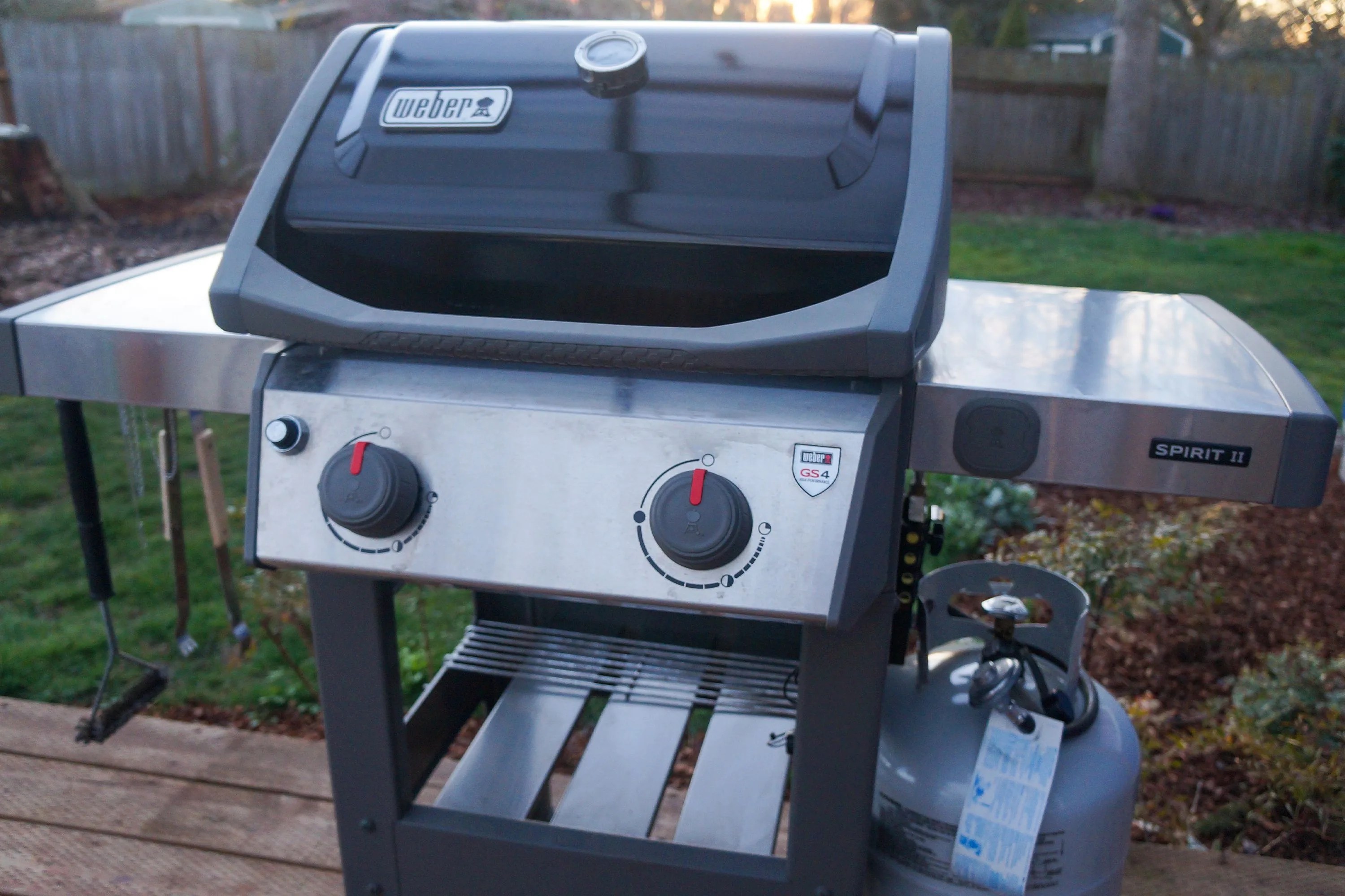 close up of the front of a weber grill on a backyard patio