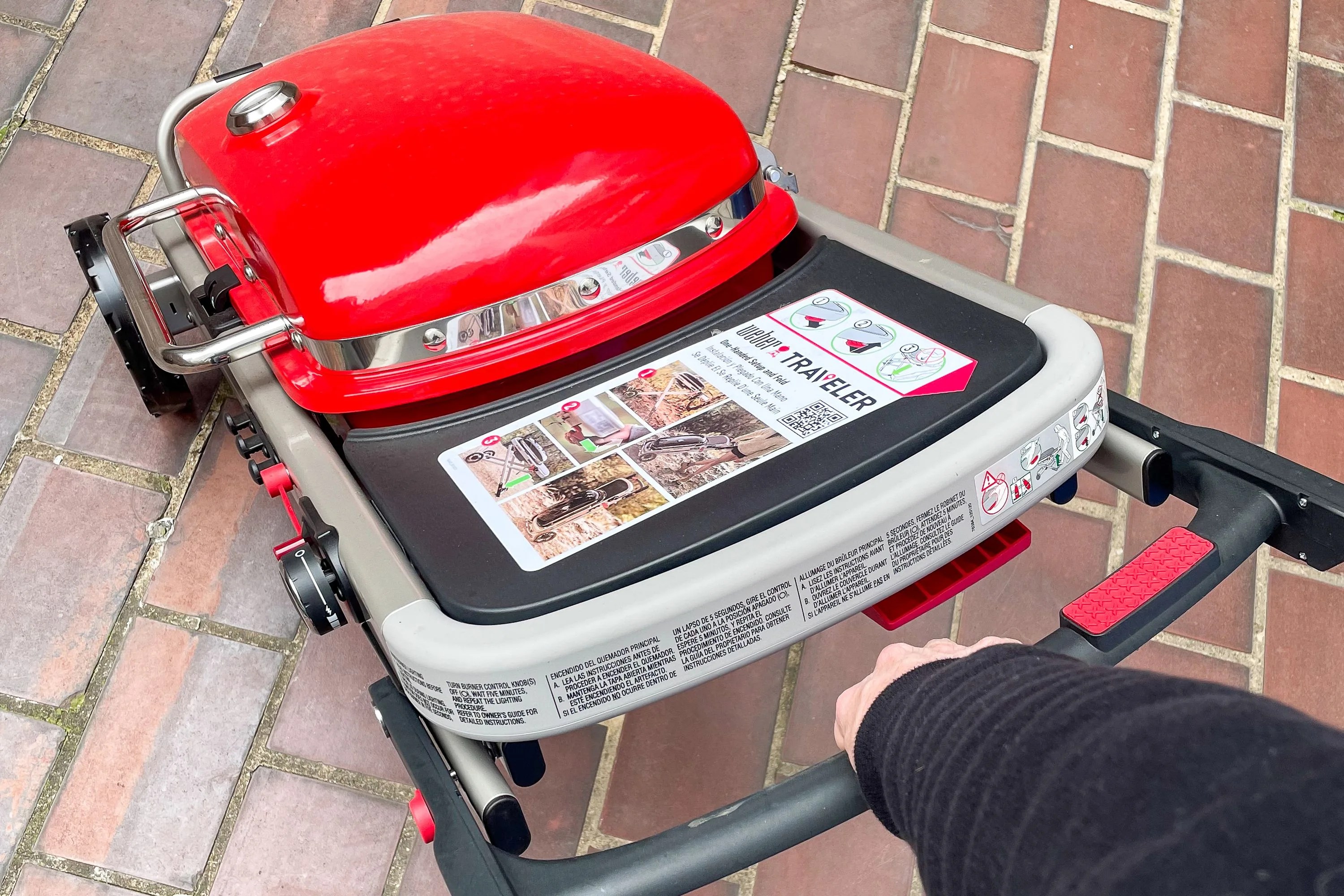 a person pulling a traveling grill