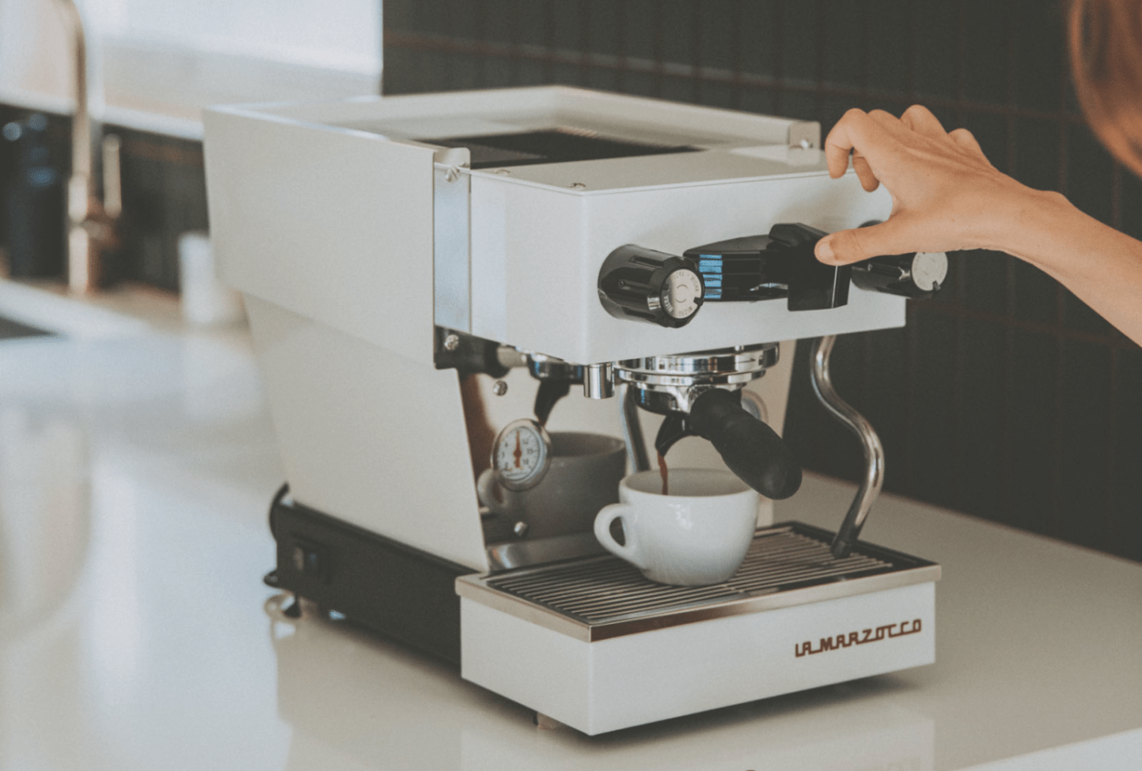 a woman using an espresso machine