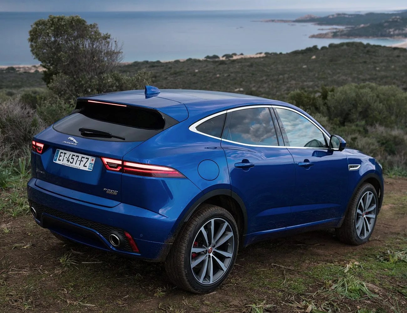 jaguar e pace parked on a hill overlooking the ocean