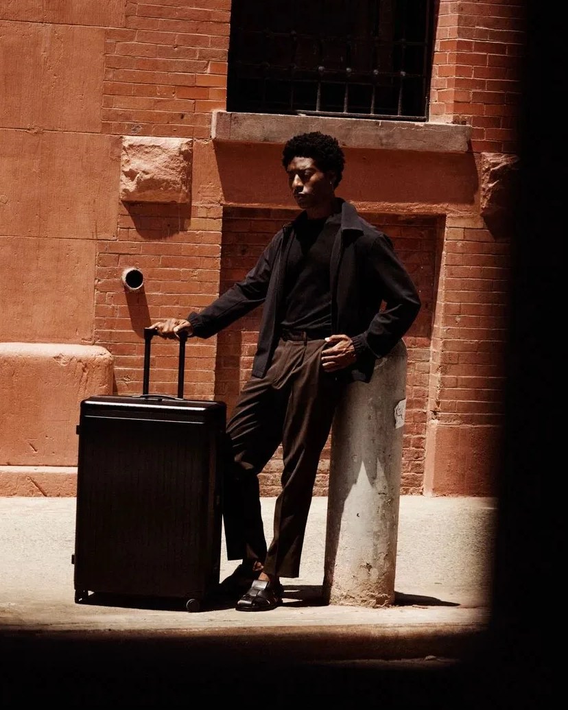 man standing with carl friedrik black luggage