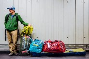 a man standing next to a pile of patagonia black hole bags