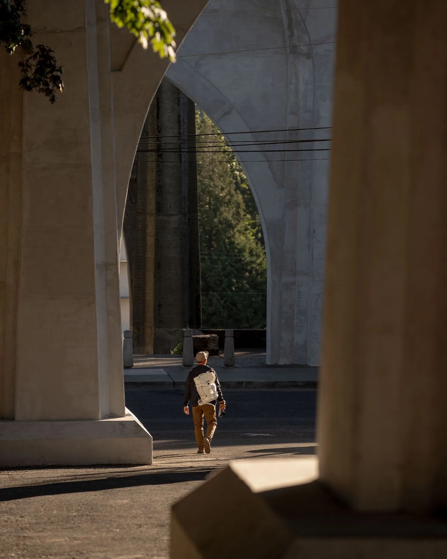 man walking carrying white camelbak backpack