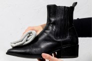 a person cleaning a leather boot