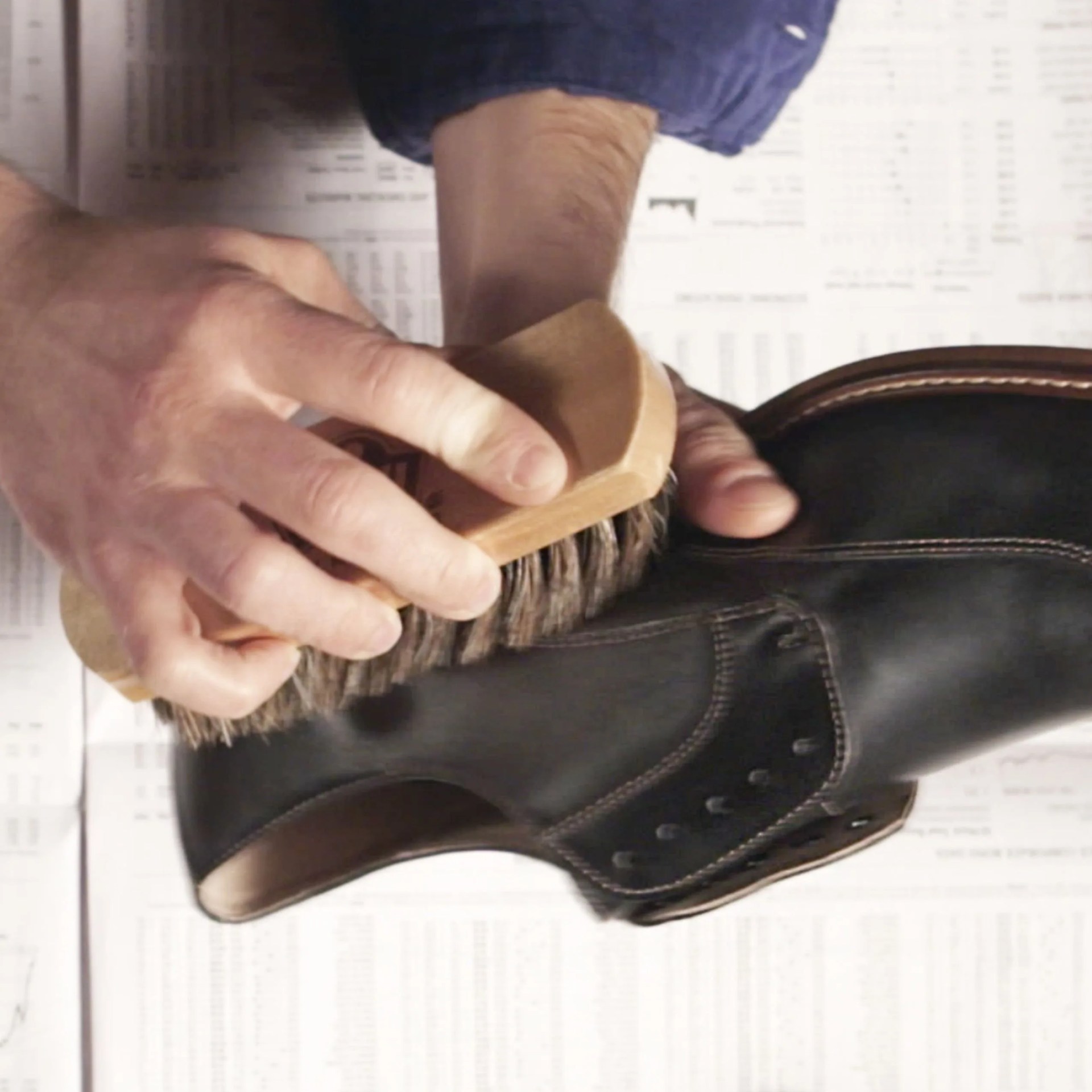 a man using a brush on a leather boot