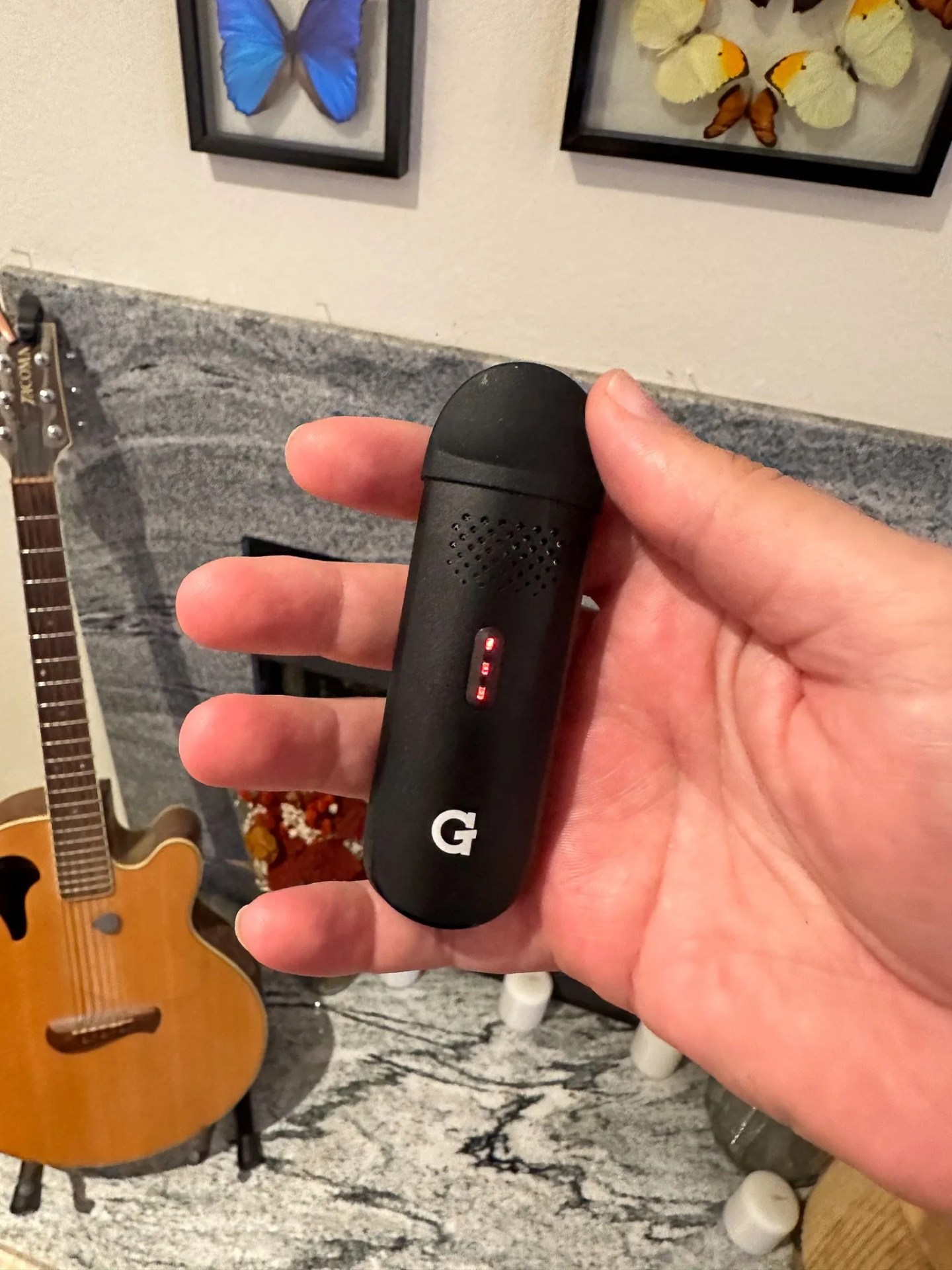 a person holding a g pen vape