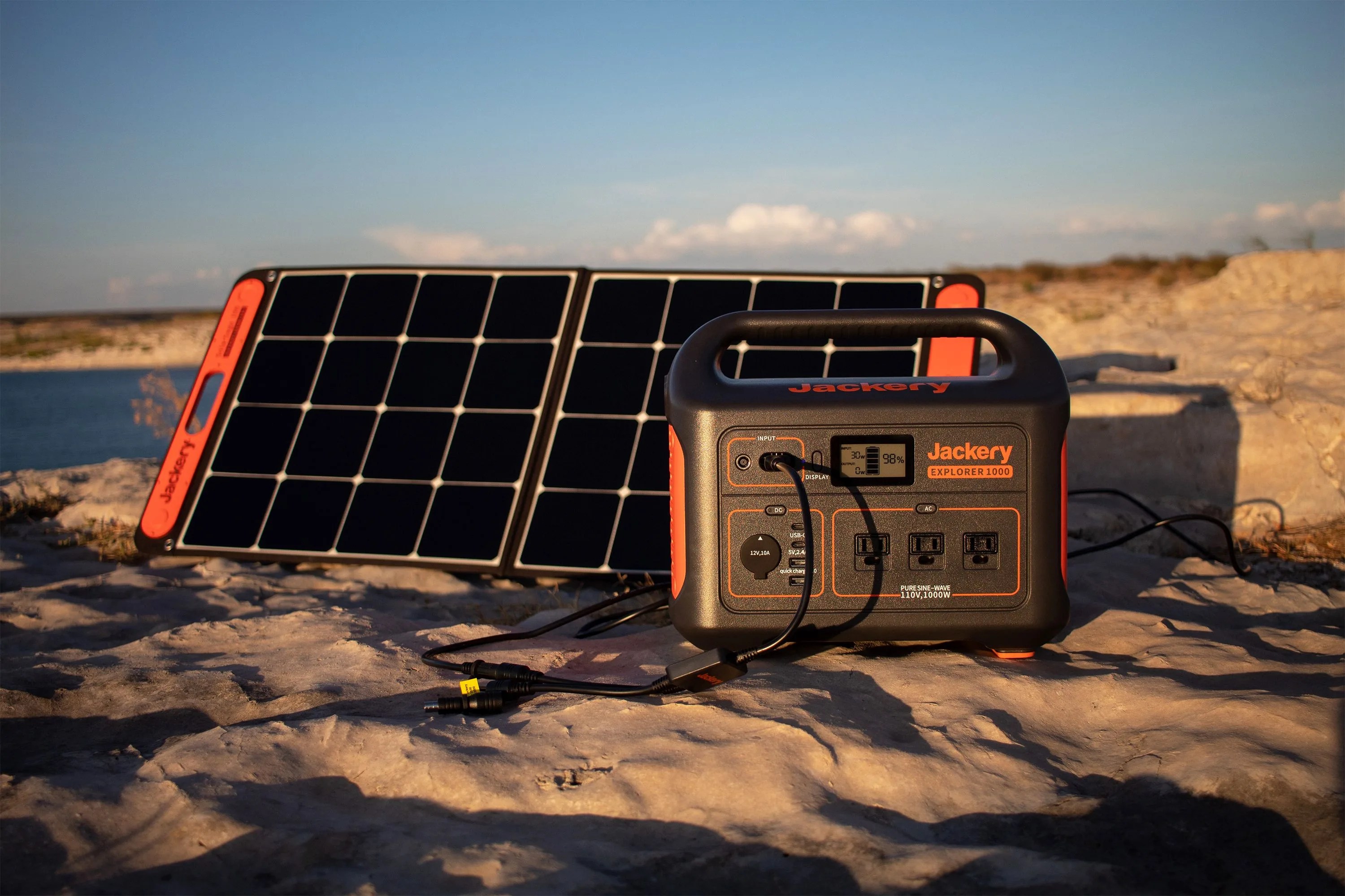 jackery power outlet and solar panel in sand