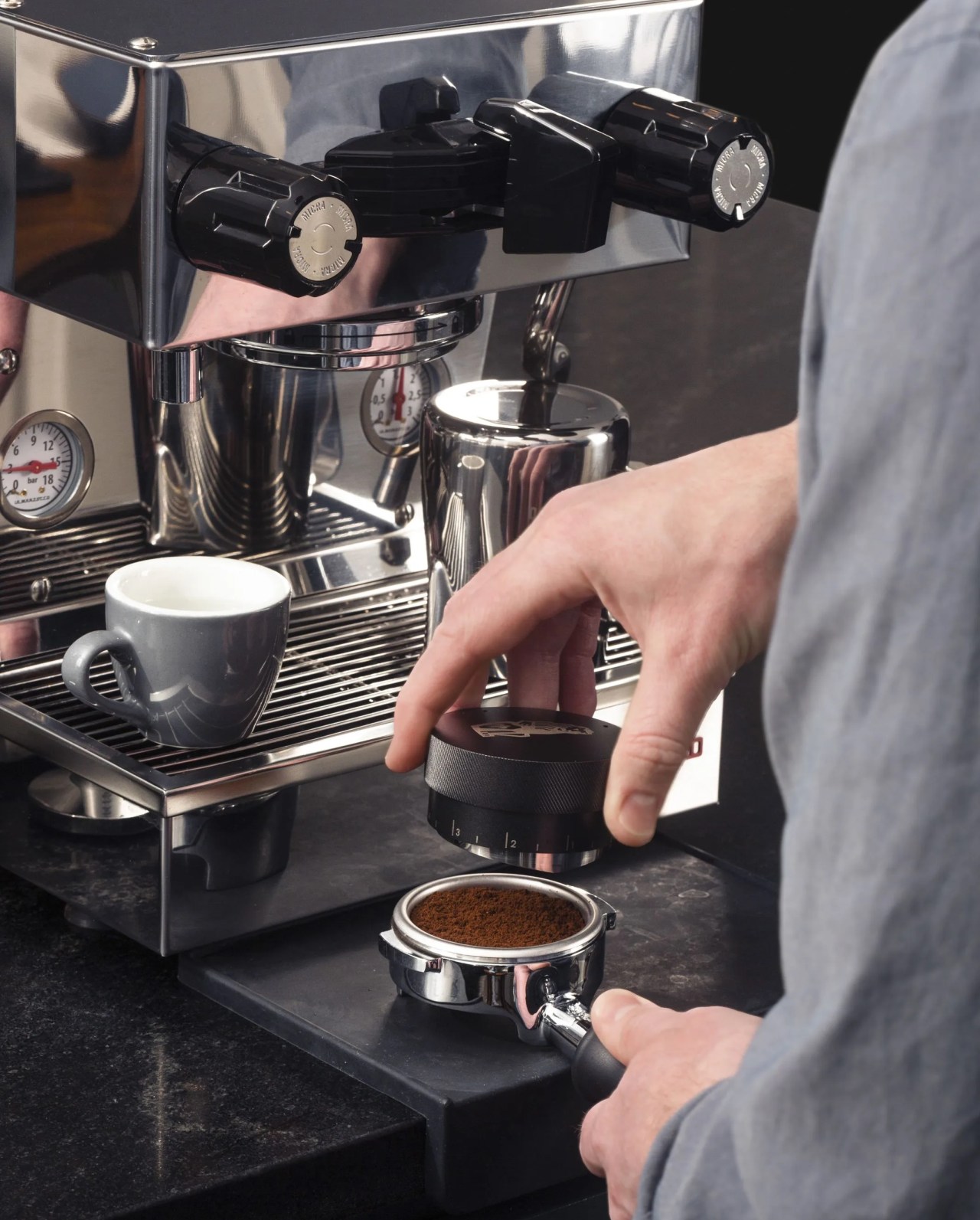 a man making espresso with an espresso machine