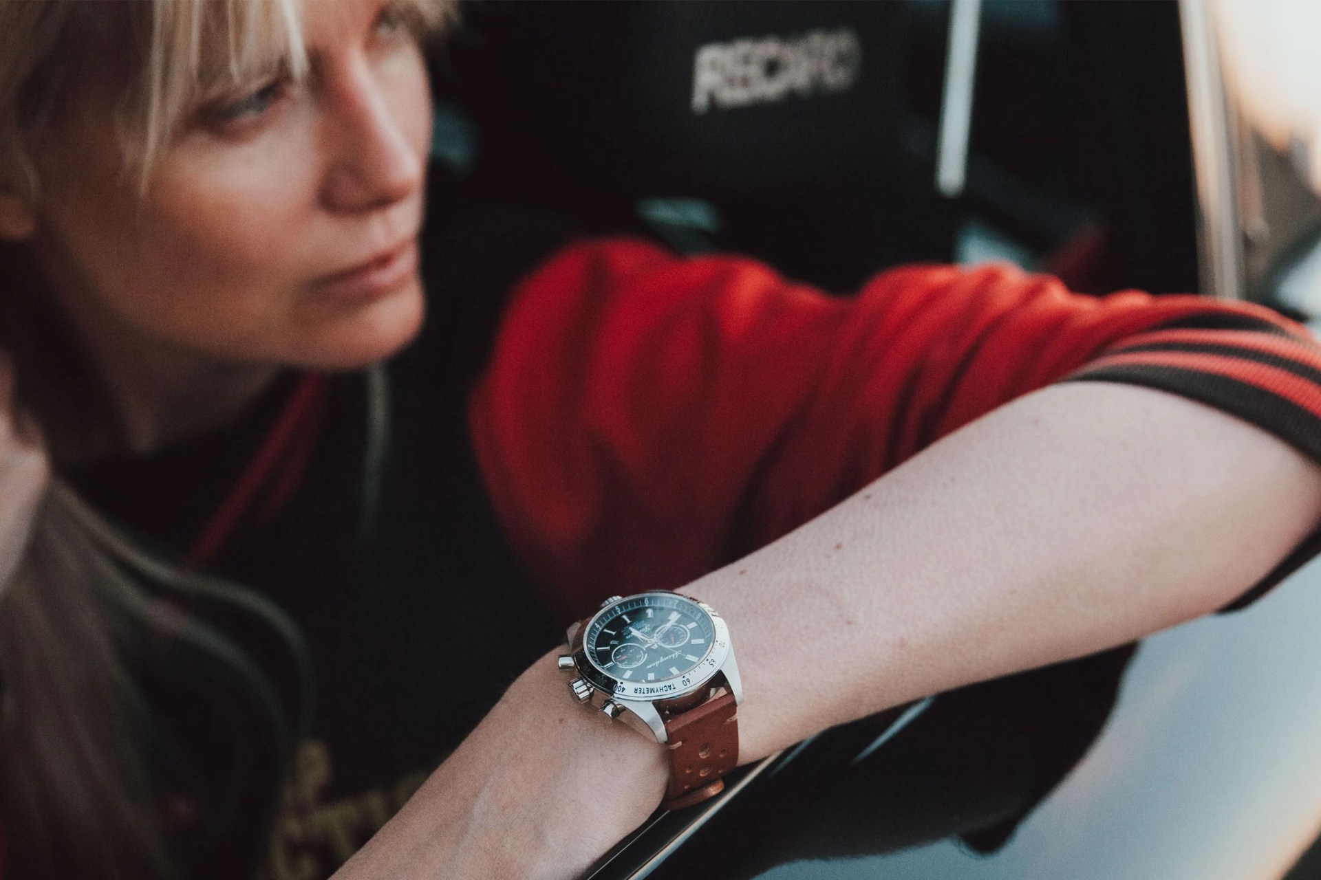 a woman sitting in a car wearing a watch