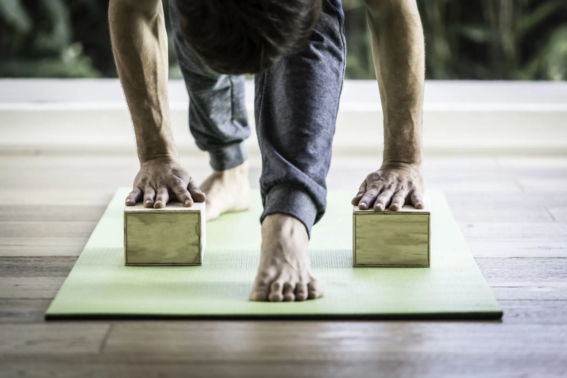 man doing yoga with blocks in yoga studio