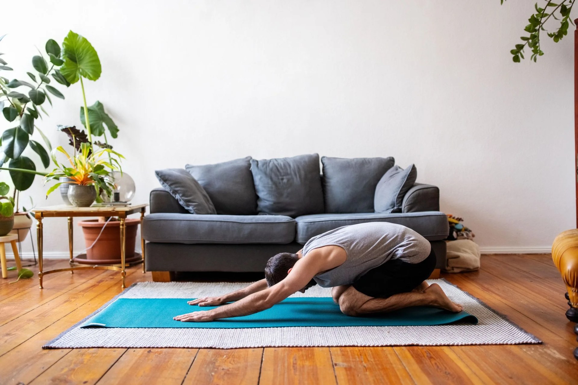 man in childs pose at home