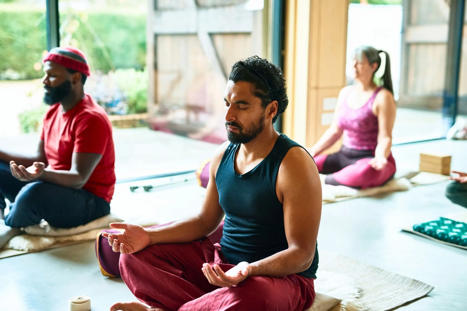 mid adult man meditating in yoga class