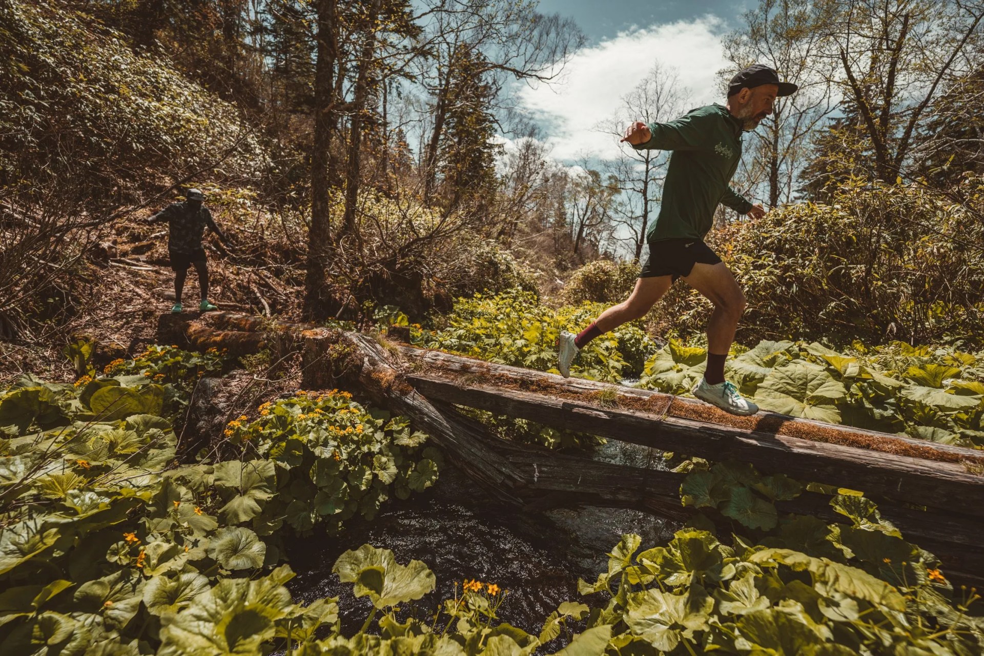 two man running across log wearing roark run amok collection