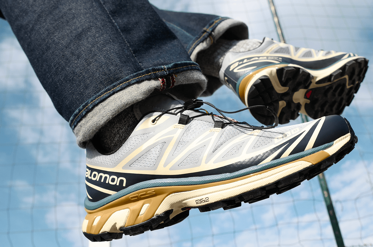 a close up of someone wearing salomon sneakers