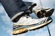 a close up of someone wearing salomon sneakers