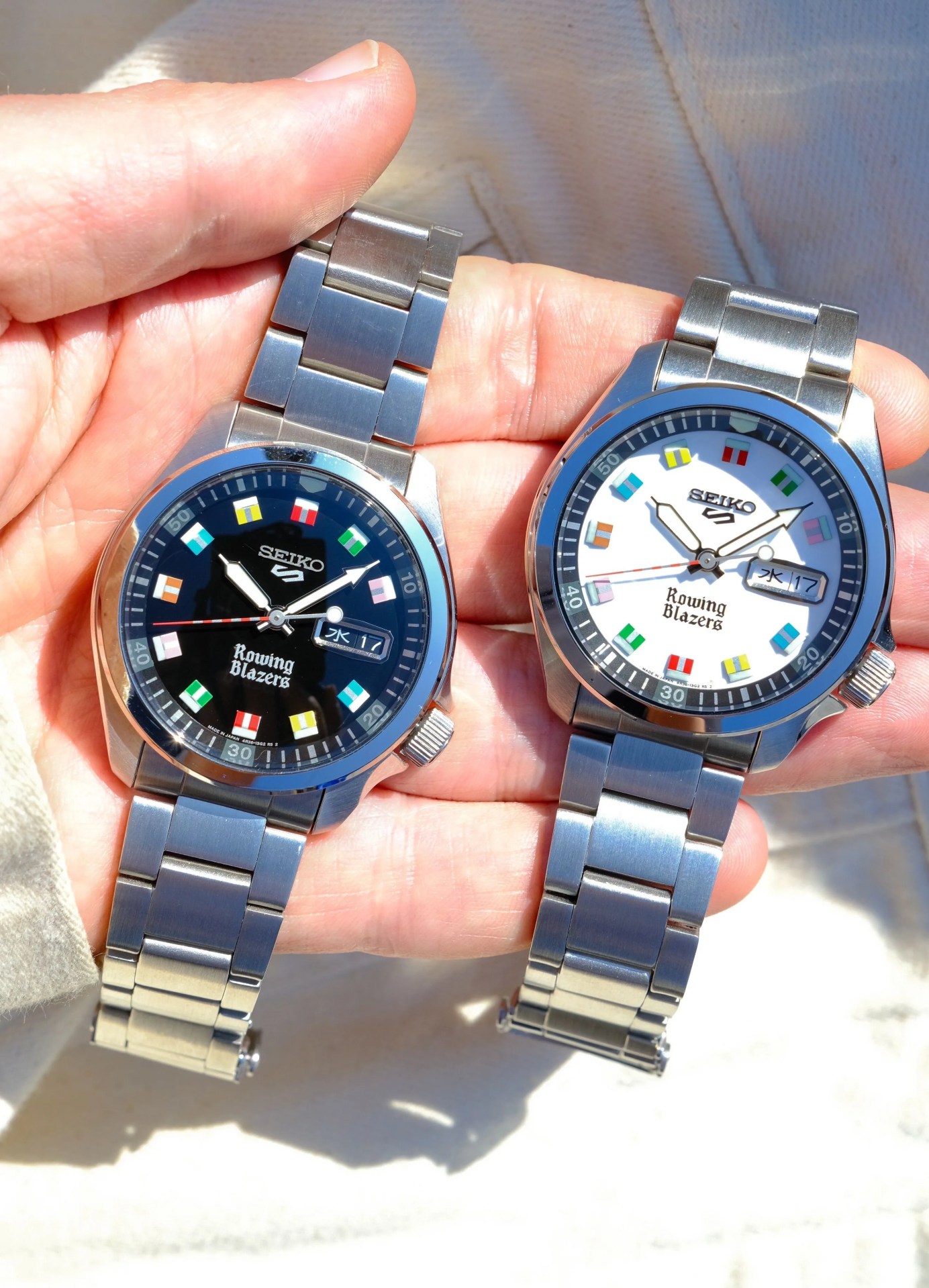 two colorful seiko watches held in hand