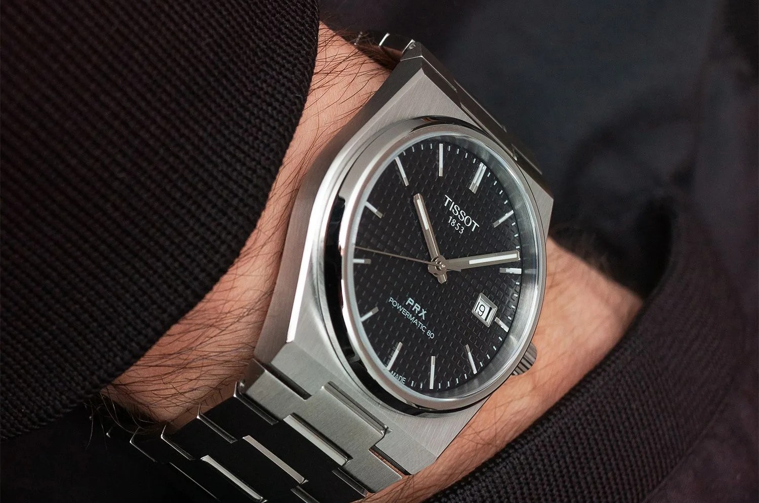 tissot prx watch worn on wrist with hand in pocket