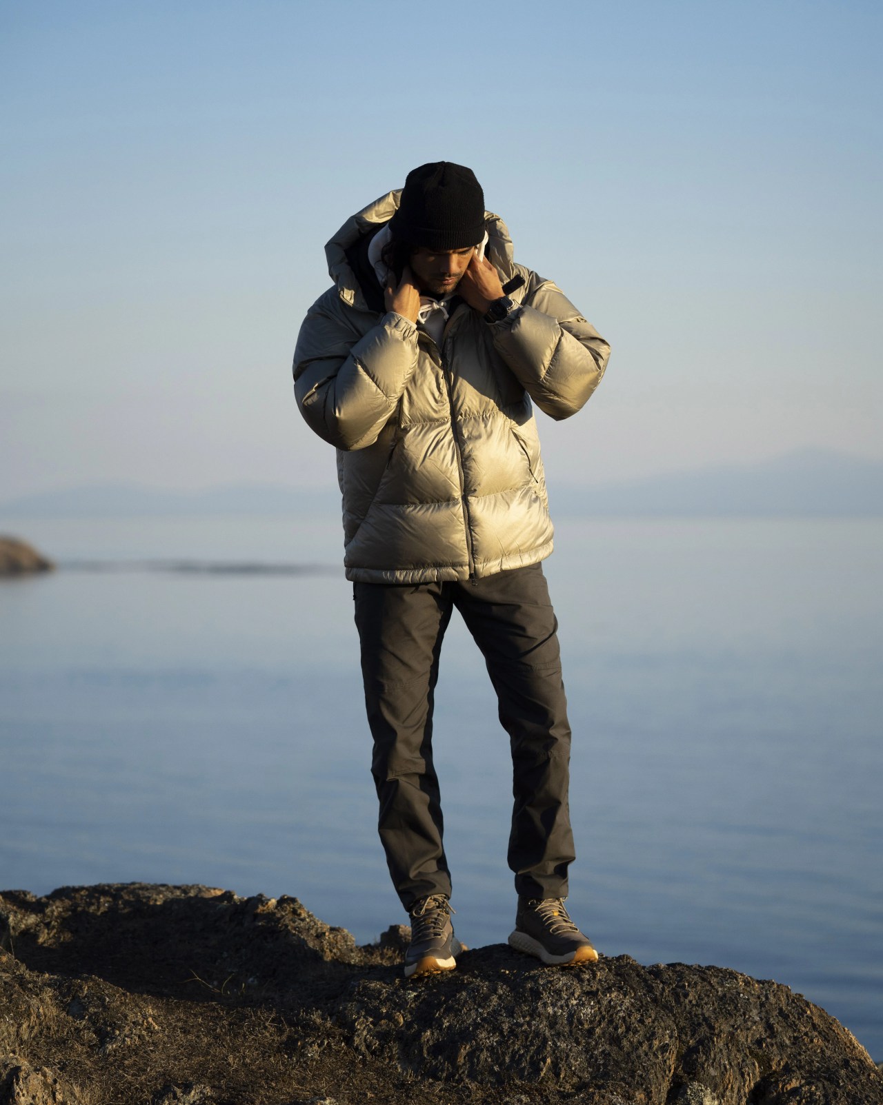 angel rodriguez adjusting the collar of his goldwin parka next to a lake