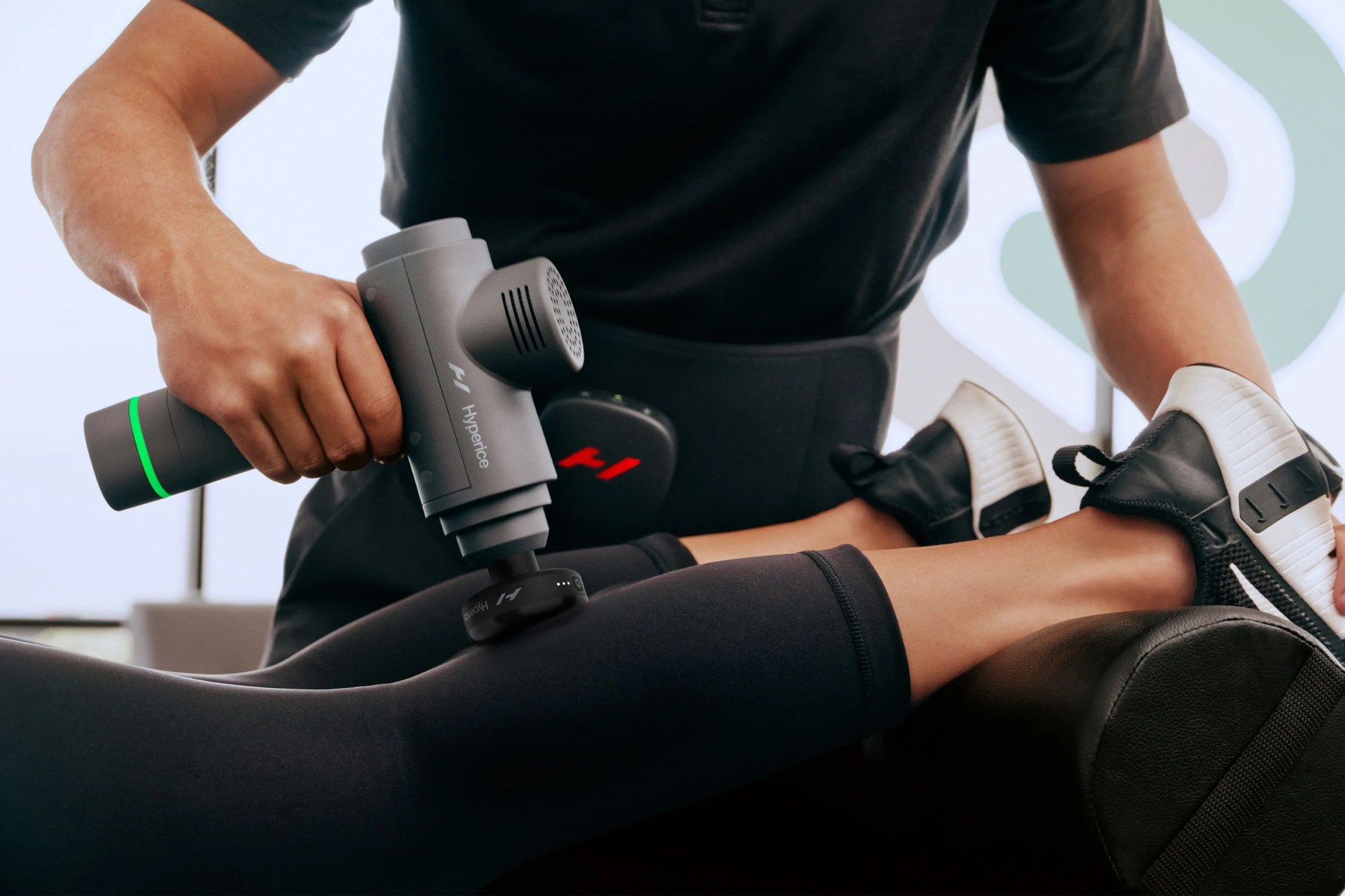 a person using a massage gun on someones calf
