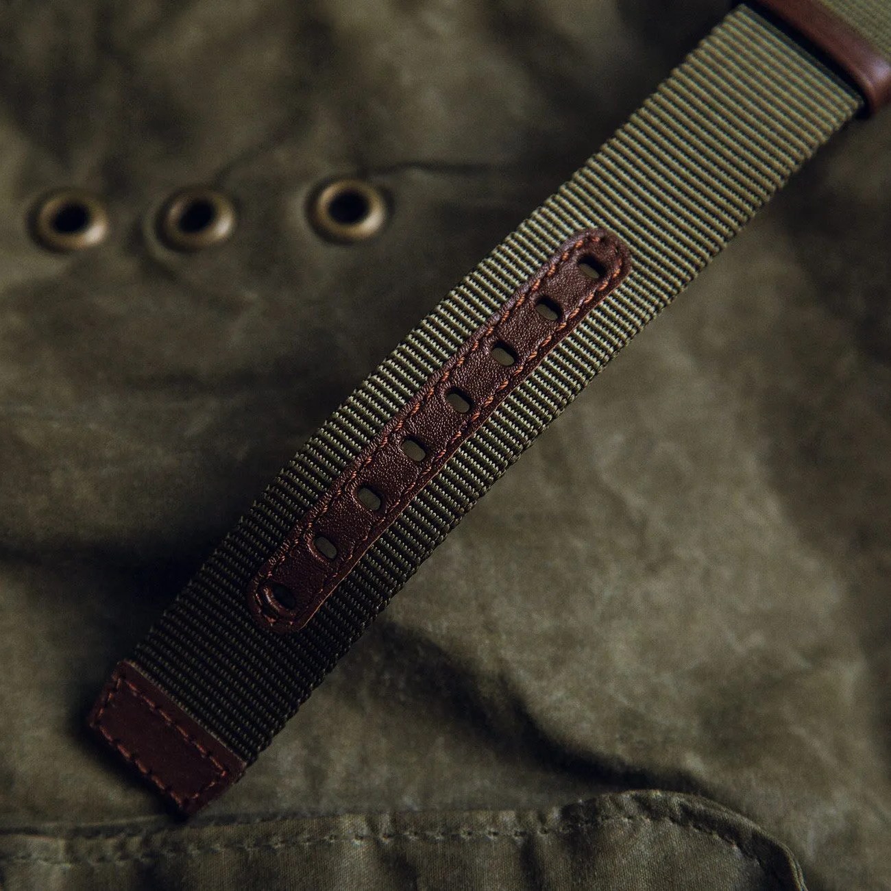 a green watch strap on green fabric
