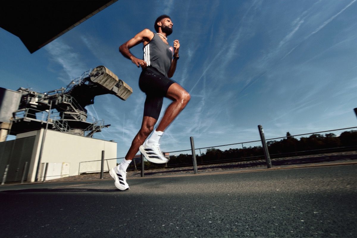 man running wearing adidas white sneakers