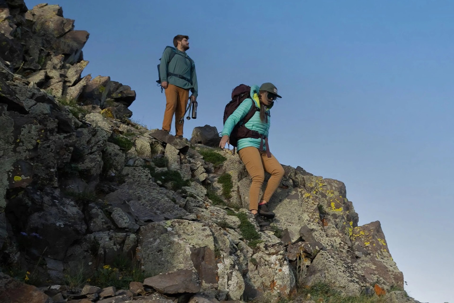 two people hiking on rocks
