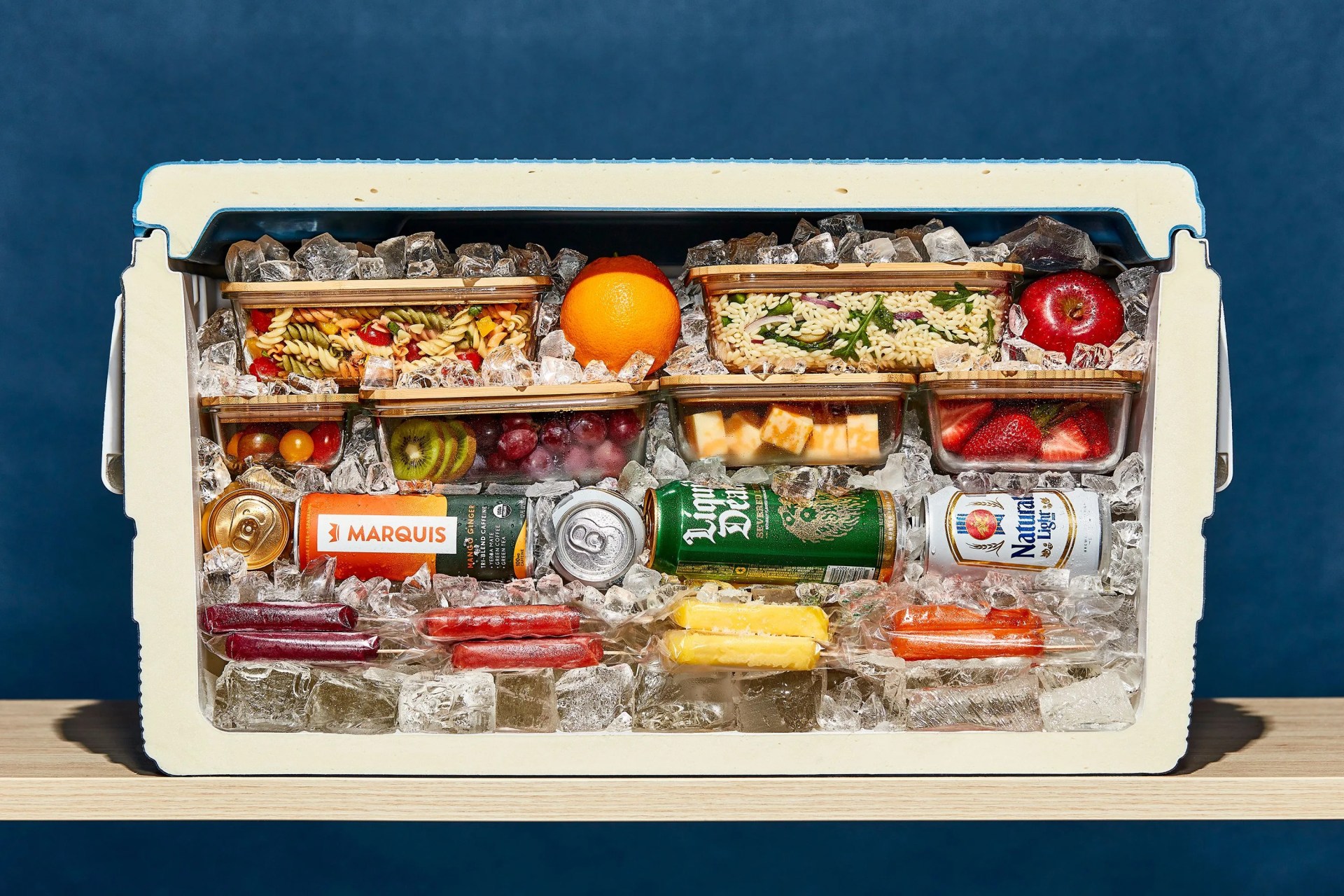 inside of a packed cooler cut in half with food and ice