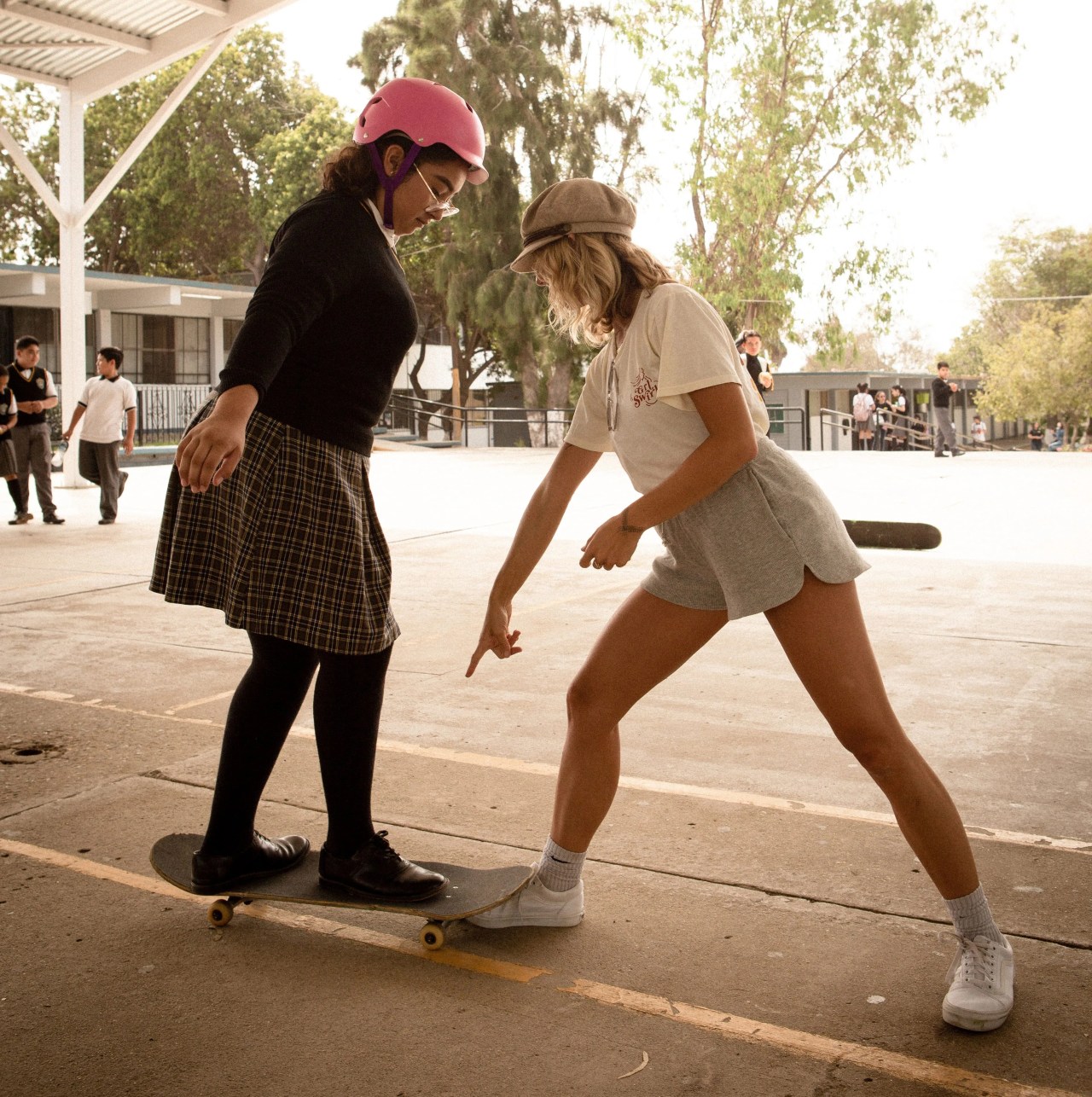 a woman teaching a girl how to skateboard
