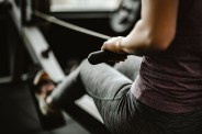 close up of unrecognizable female athlete having sports training on rowing machine in a gym