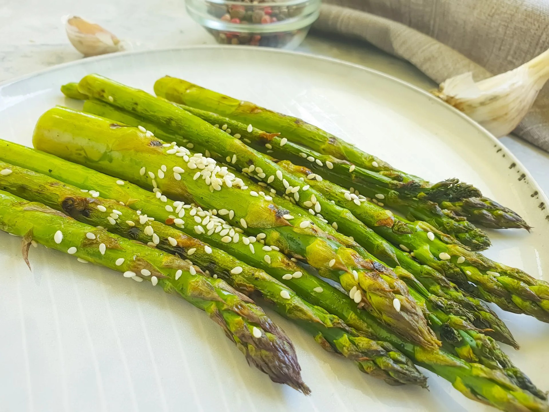 fried asparagus in a plate on a concrete background