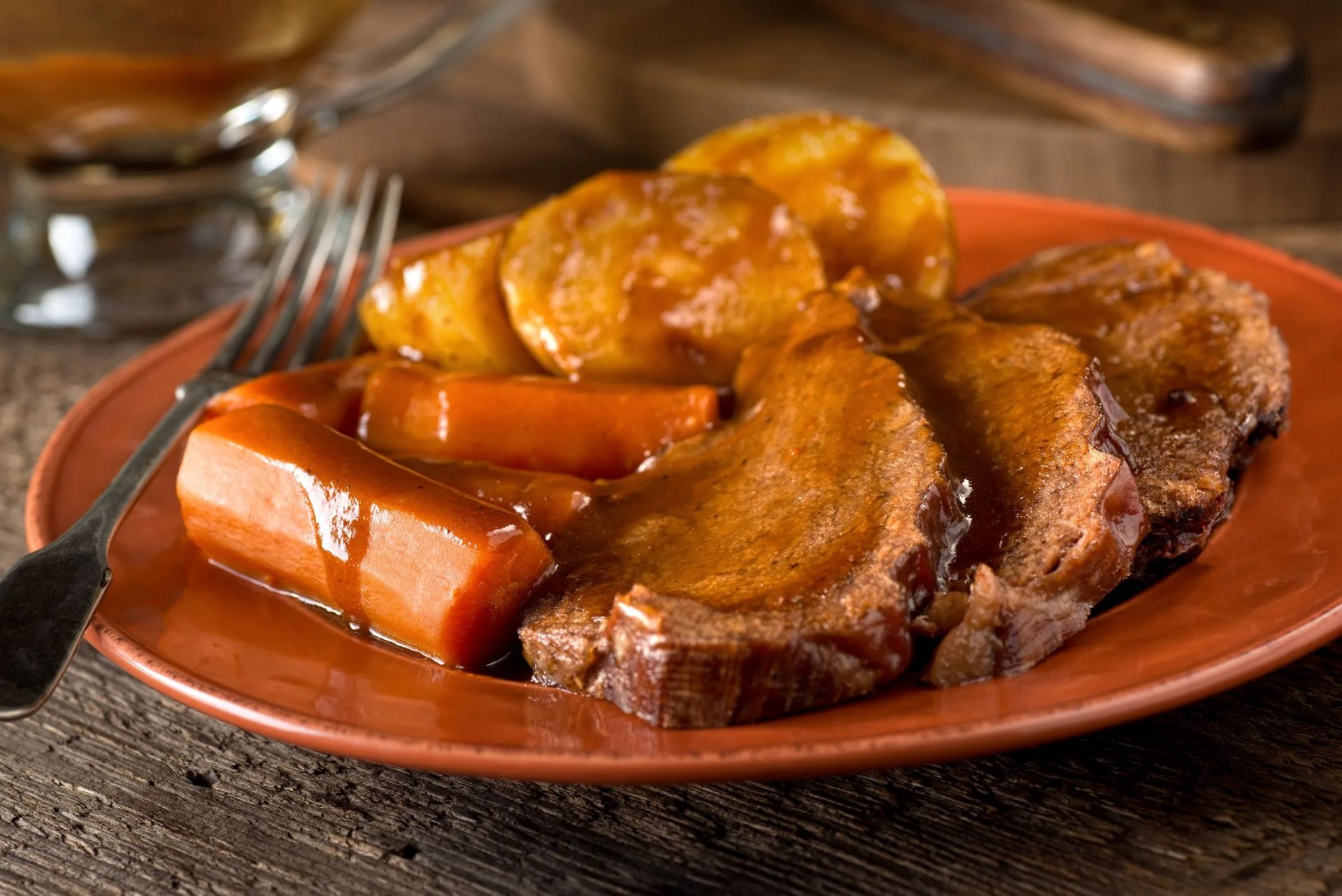 a delicious homemade pot roast dinner with potatoes, carrots, and gravy