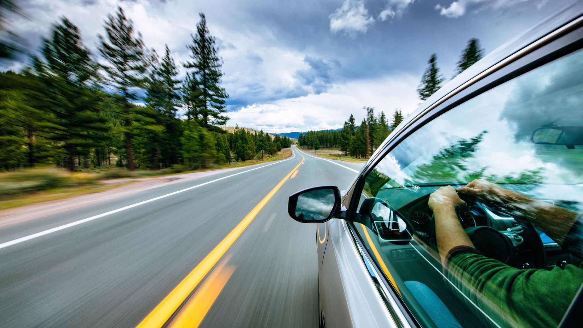 man driving electric vehicle road trip through sierra nevada