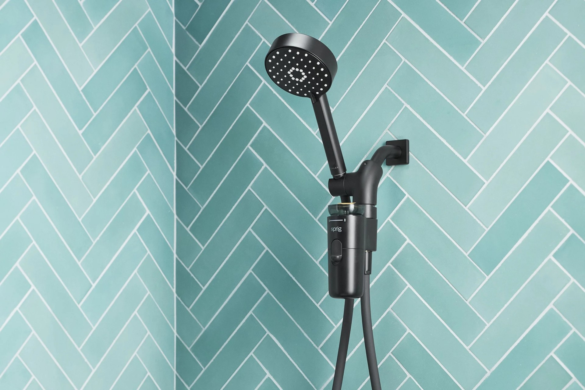 a sprig shower head in a turquoise tiled shower
