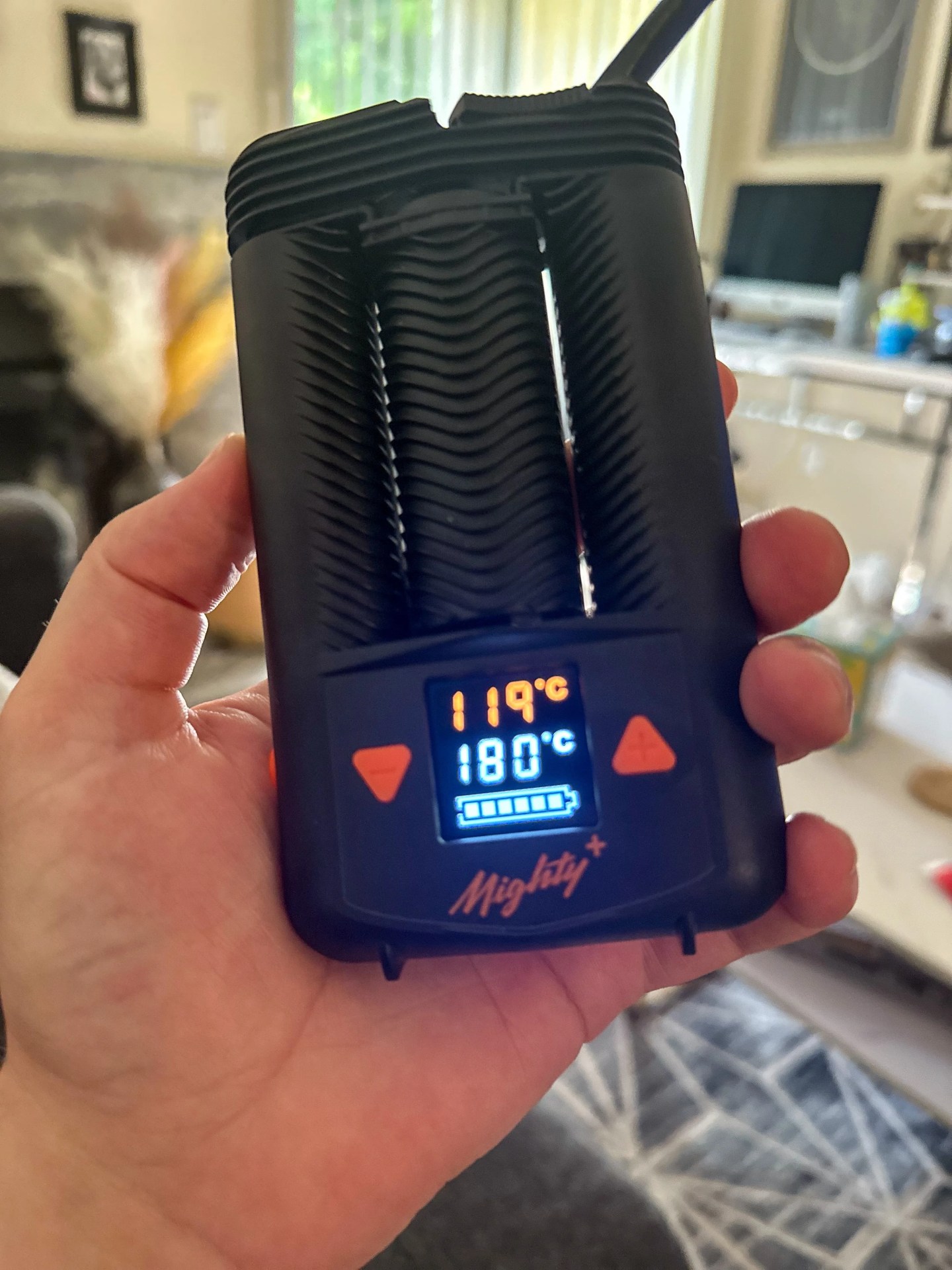 a person holding a mighty plus weed vape