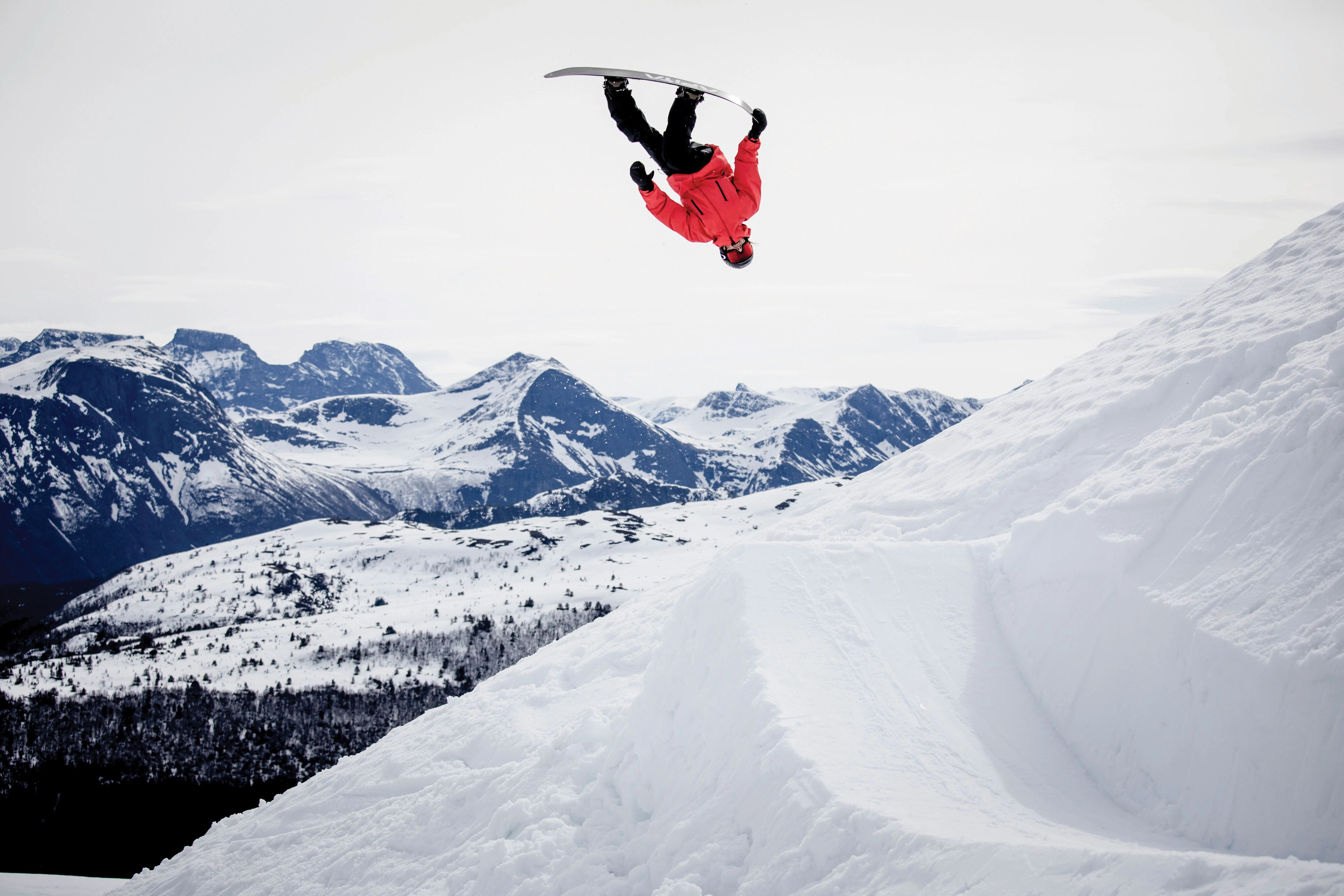 snowboarder mid air on a snowy mountain