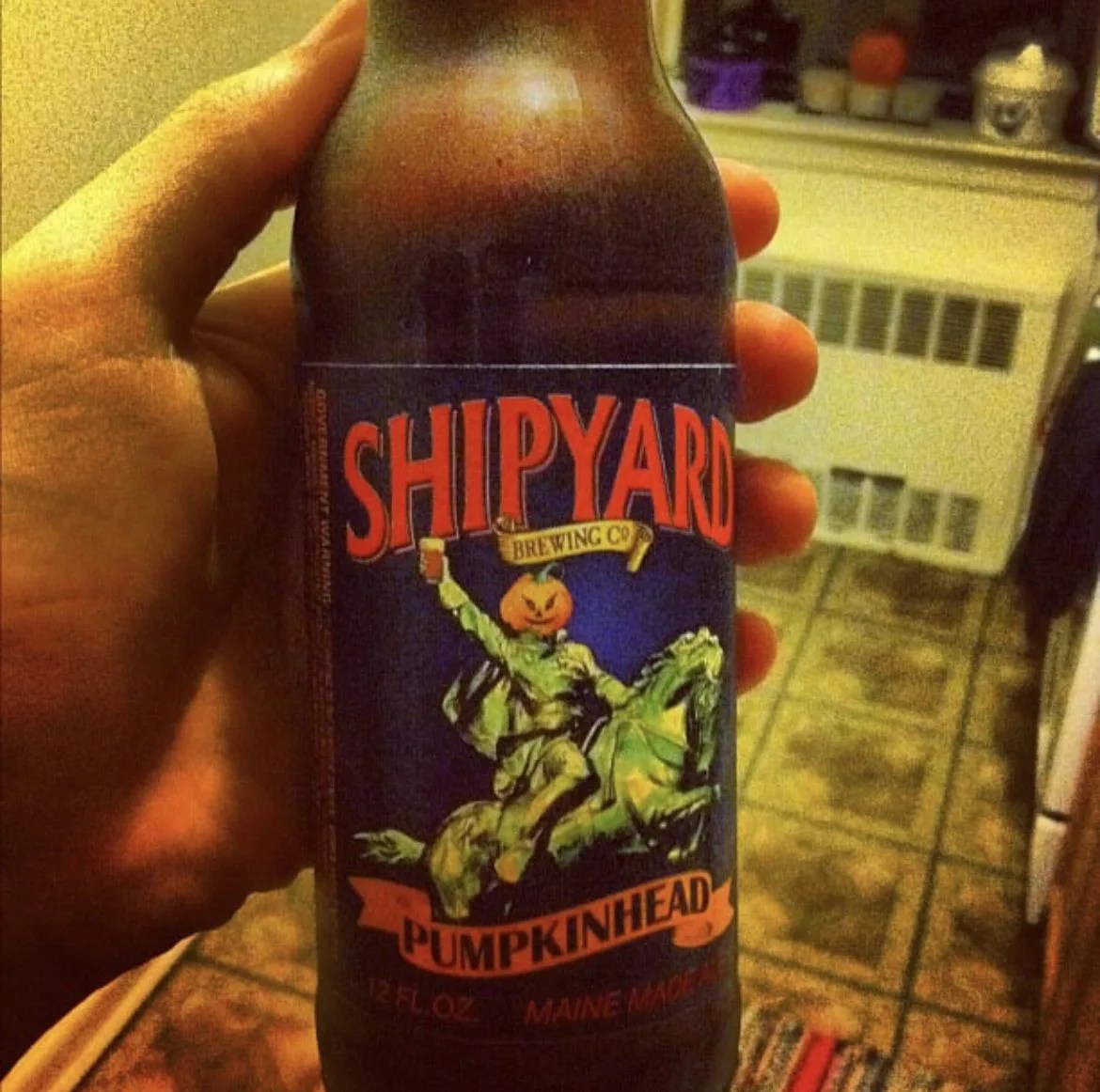 hand holding pumpkin beer bottle