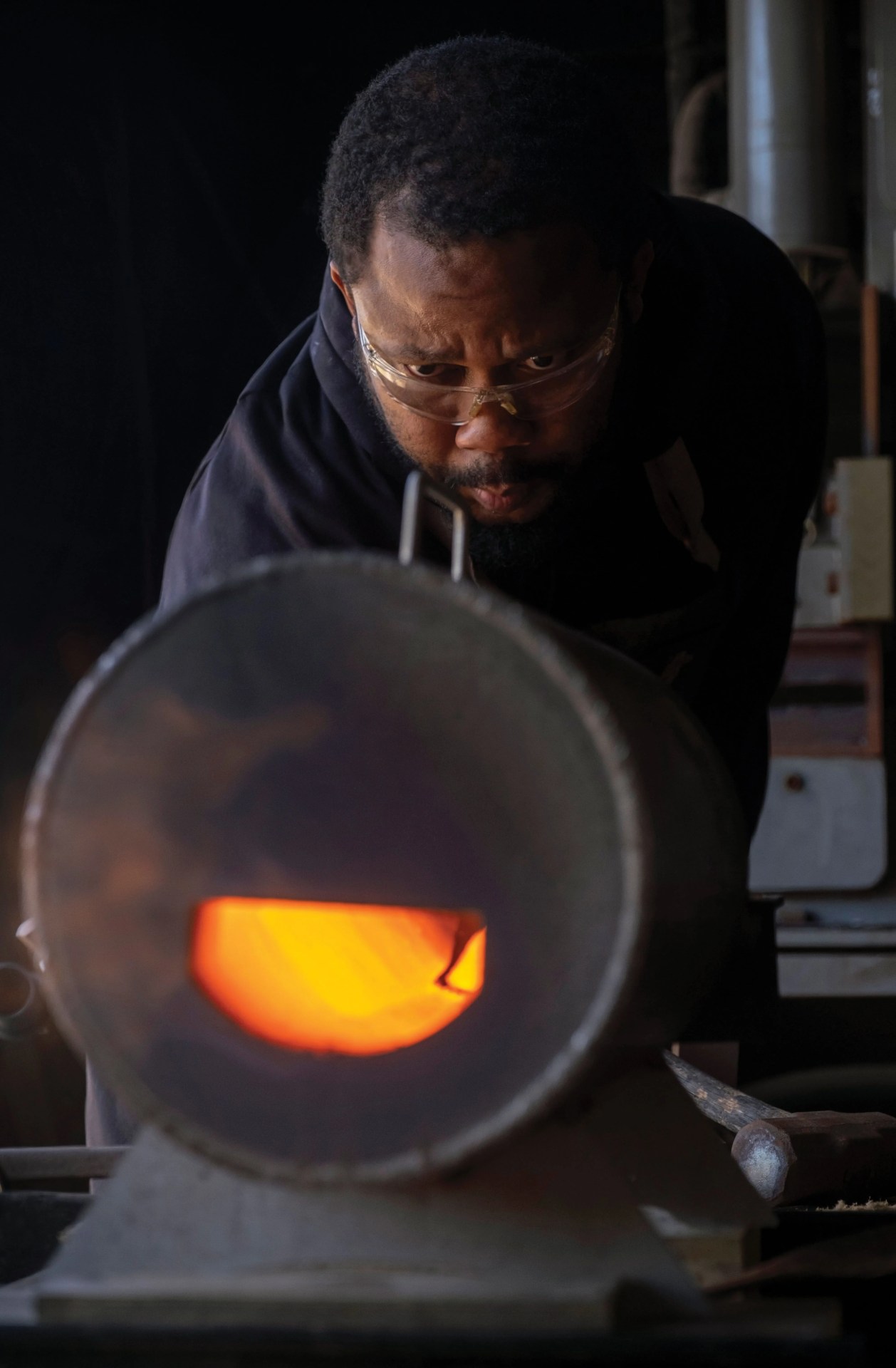 quintin middleton closely monitors carbon steel in his forge as it heats up in his workspace